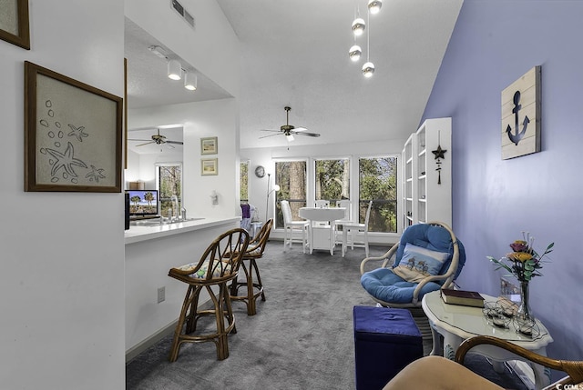 interior space featuring ceiling fan, carpet floors, a textured ceiling, and vaulted ceiling