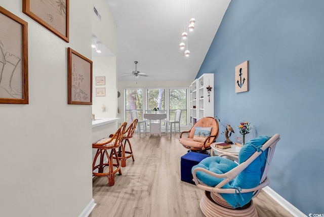 sitting room featuring a ceiling fan, high vaulted ceiling, visible vents, and light wood finished floors