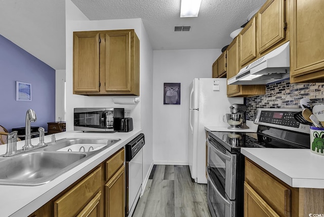 kitchen featuring sink, white dishwasher, light hardwood / wood-style floors, a textured ceiling, and stainless steel electric range