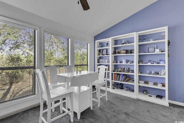 carpeted dining area with a textured ceiling, ceiling fan, and lofted ceiling