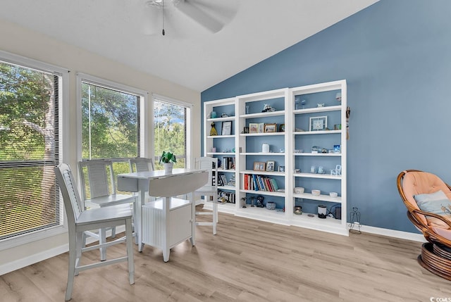interior space with a ceiling fan, vaulted ceiling, and light wood-type flooring
