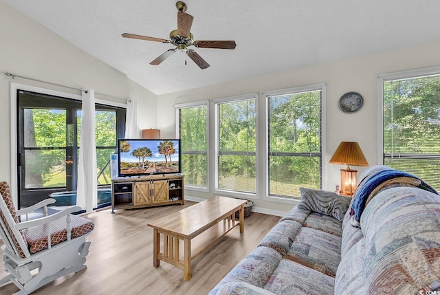 living room featuring a healthy amount of sunlight, ceiling fan, light wood-style flooring, and lofted ceiling