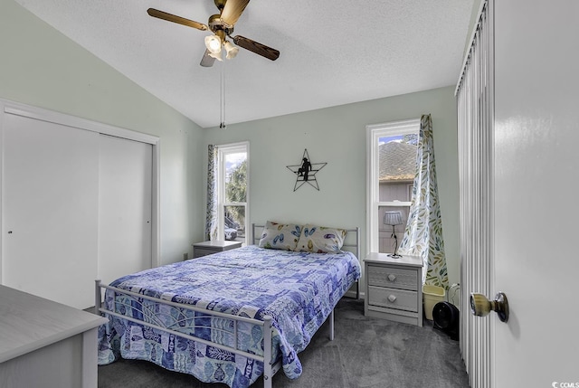 carpeted bedroom with ceiling fan, a closet, a textured ceiling, and lofted ceiling