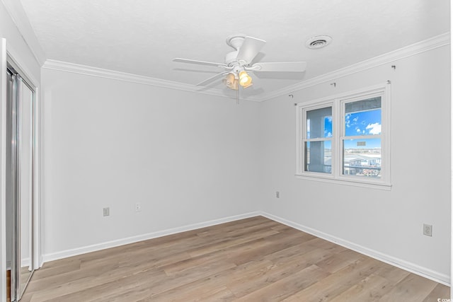 unfurnished room featuring light wood finished floors, ceiling fan, visible vents, and ornamental molding