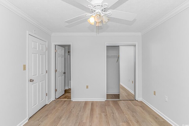 unfurnished bedroom with a closet, a textured ceiling, baseboards, and wood finished floors