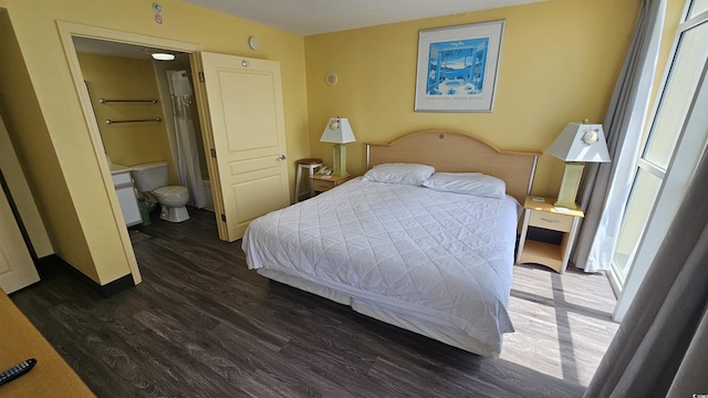 bedroom with ensuite bath and dark hardwood / wood-style flooring