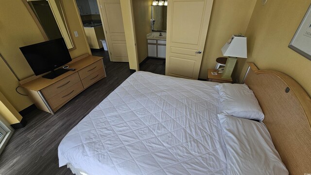 bedroom featuring dark hardwood / wood-style flooring and connected bathroom