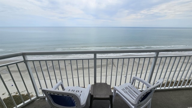 balcony featuring a water view and a beach view