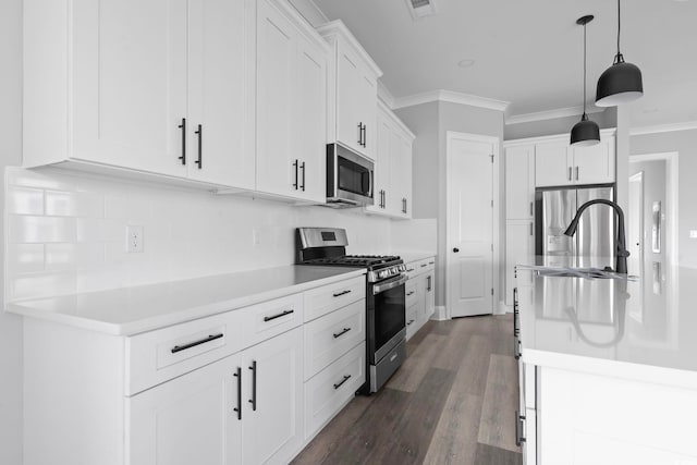 kitchen with white cabinetry, stainless steel appliances, ornamental molding, dark hardwood / wood-style flooring, and decorative light fixtures