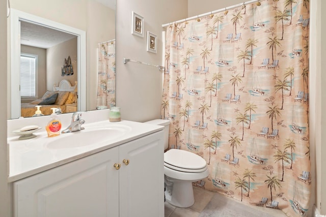 bathroom featuring tile patterned flooring, vanity, curtained shower, and toilet