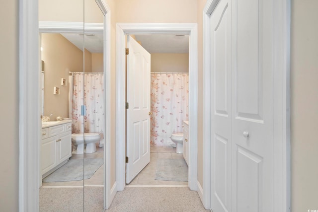 bathroom with a shower with shower curtain, vanity, and toilet