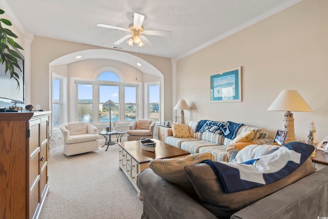 living room with ceiling fan, light colored carpet, ornamental molding, and a water view