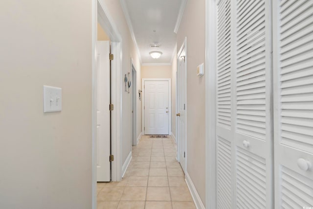 hall with light tile patterned floors and crown molding