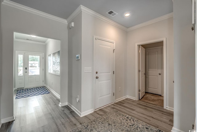 foyer with ornamental molding and light wood-type flooring