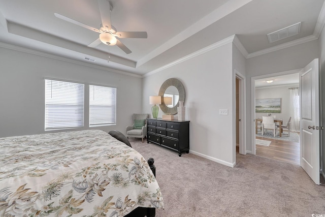 bedroom featuring carpet flooring, visible vents, a tray ceiling, and baseboards
