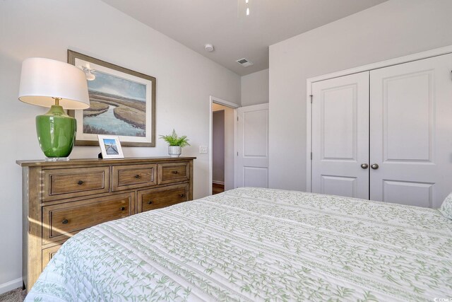 bedroom with a closet, baseboards, and visible vents