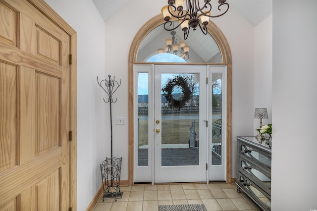 entryway featuring light tile patterned floors, vaulted ceiling, and a notable chandelier