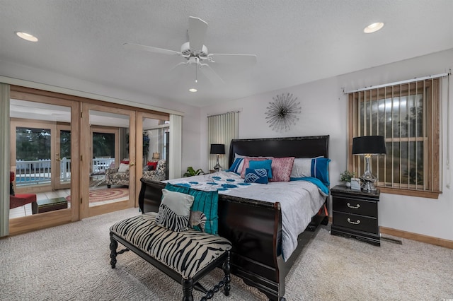 carpeted bedroom with ceiling fan, access to exterior, and a textured ceiling