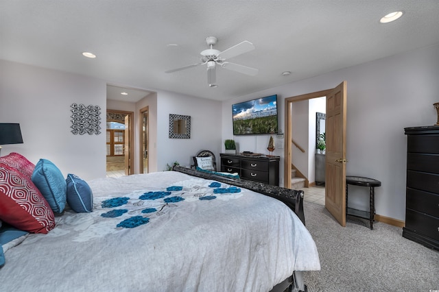 bedroom with ensuite bathroom, ceiling fan, and light colored carpet