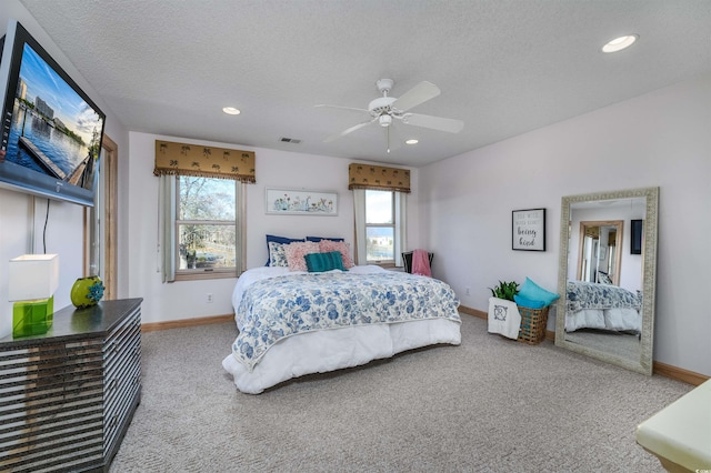 carpeted bedroom with a textured ceiling and ceiling fan