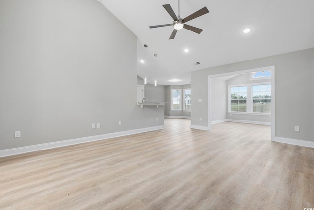 unfurnished living room featuring lofted ceiling, light hardwood / wood-style floors, and ceiling fan