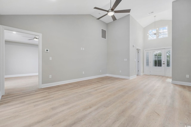 unfurnished living room featuring ceiling fan with notable chandelier, light hardwood / wood-style flooring, and high vaulted ceiling