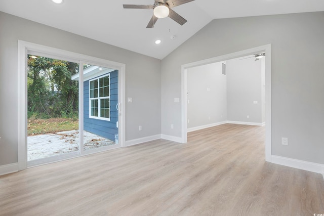 spare room with light wood-type flooring, plenty of natural light, ceiling fan, and vaulted ceiling