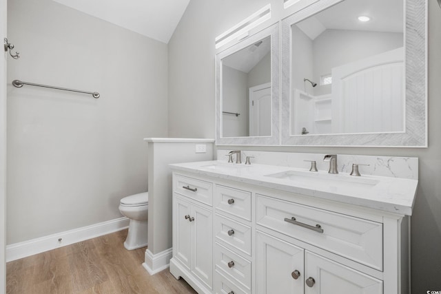 bathroom featuring vanity, lofted ceiling, hardwood / wood-style floors, and toilet