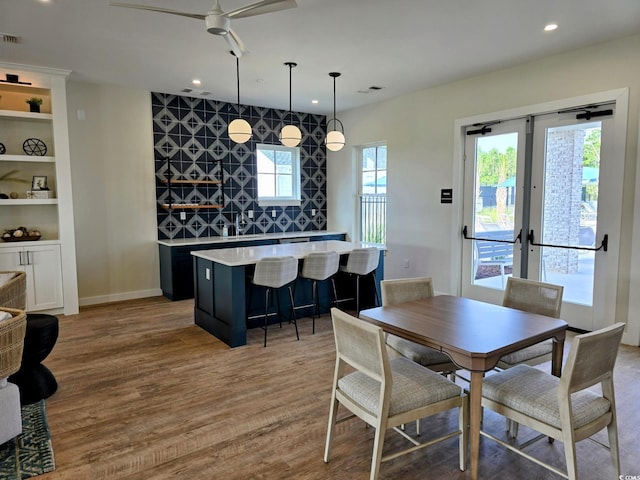 dining space with ceiling fan and light hardwood / wood-style flooring