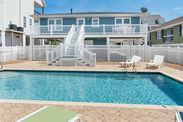 view of swimming pool with cooling unit and a patio