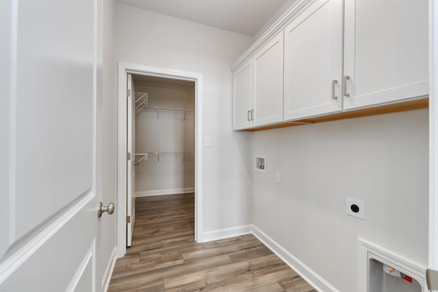 washroom with washer hookup, electric dryer hookup, light hardwood / wood-style floors, and cabinets