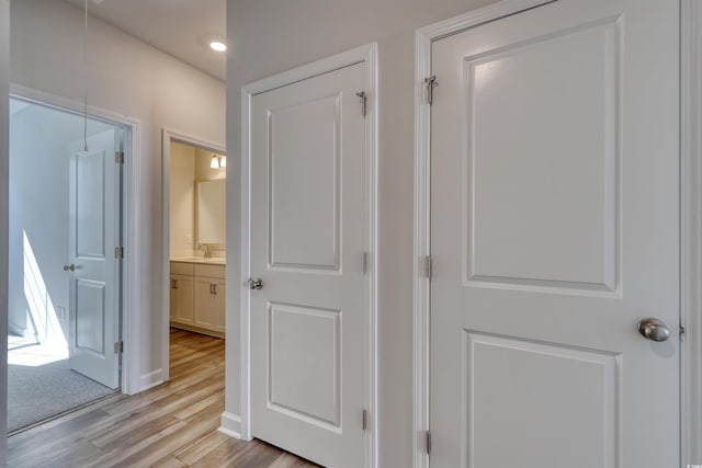 hall with light wood-type flooring and sink