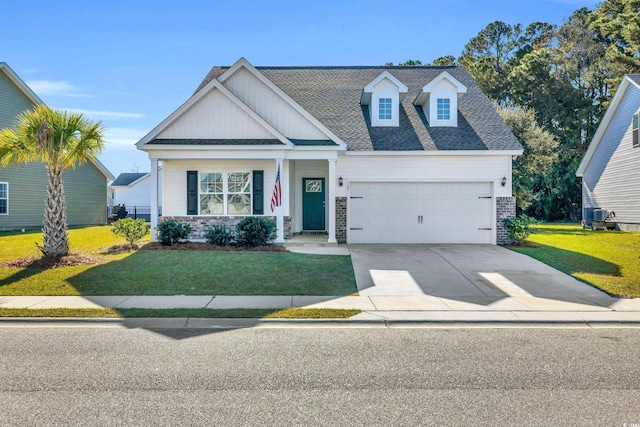 view of front of home featuring a garage, brick siding, driveway, roof with shingles, and a front yard