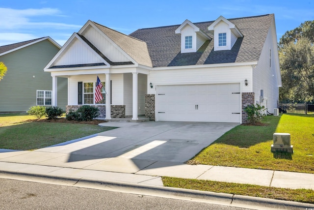 view of front of property with brick siding, covered porch, a front yard, a garage, and driveway