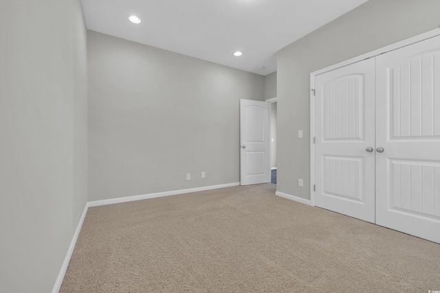 unfurnished bedroom featuring a closet, recessed lighting, carpet flooring, and baseboards