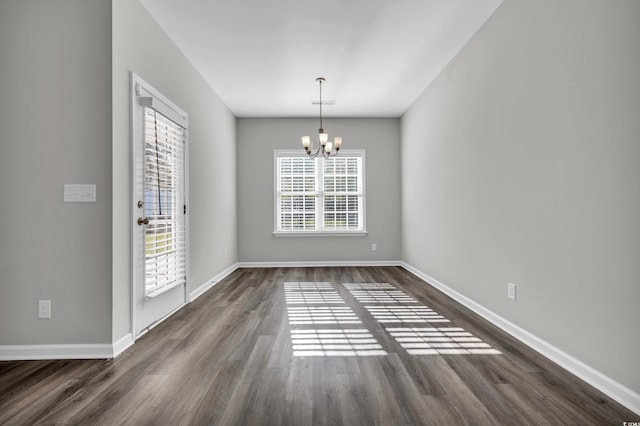 unfurnished dining area featuring an inviting chandelier, visible vents, baseboards, and dark wood-style flooring