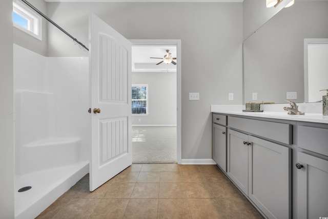 bathroom featuring vanity, baseboards, walk in shower, and tile patterned floors