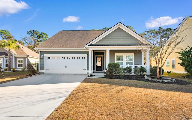 view of front facade featuring a porch, a garage, and a front lawn