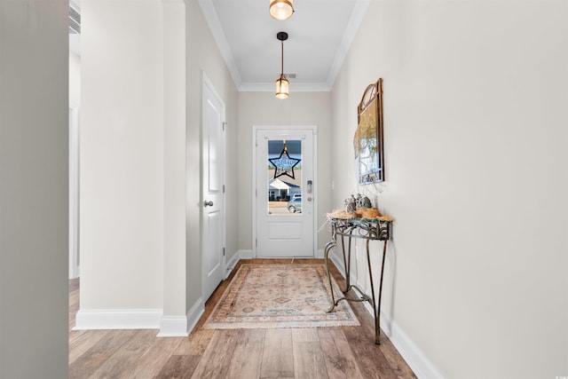 entryway with crown molding and light hardwood / wood-style floors