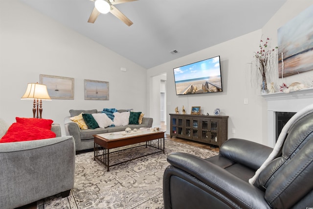 living room with ceiling fan, lofted ceiling, and light wood-type flooring