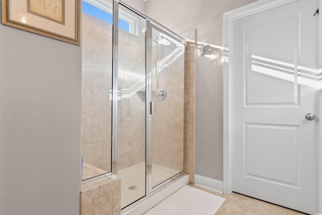 bathroom with an enclosed shower and tile patterned flooring