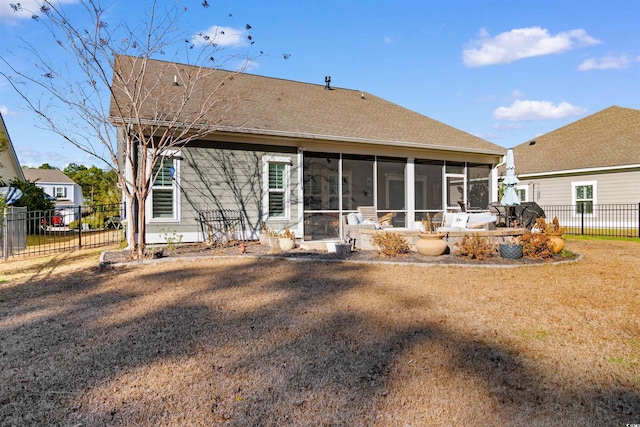 back of house with a sunroom and a lawn