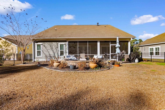 rear view of property with a sunroom and a lawn