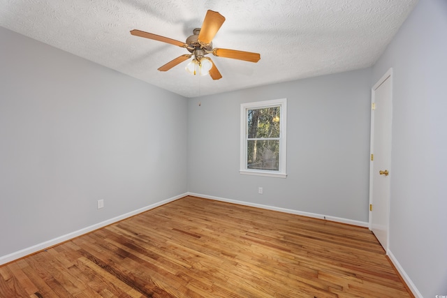 spare room with ceiling fan, light wood-type flooring, and a textured ceiling