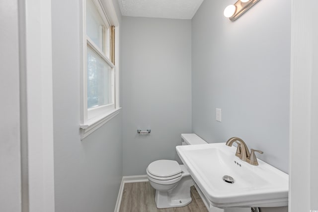 bathroom featuring hardwood / wood-style flooring, sink, a textured ceiling, and toilet