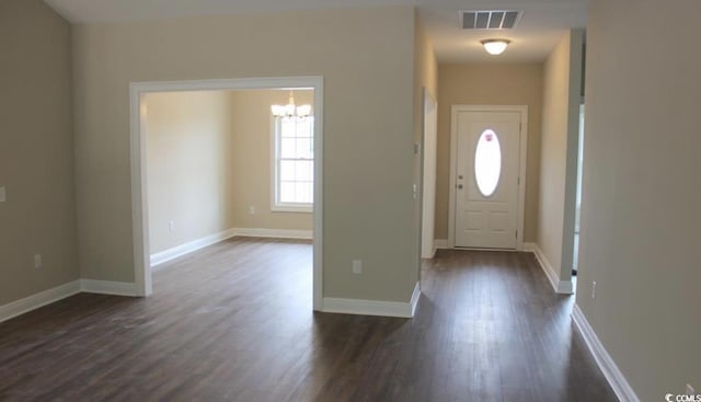 foyer entrance featuring dark hardwood / wood-style flooring and an inviting chandelier