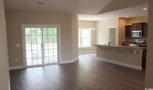 kitchen featuring dark wood-type flooring, a kitchen breakfast bar, sink, vaulted ceiling, and stainless steel appliances