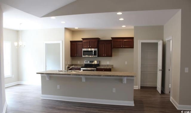 kitchen featuring sink, stainless steel appliances, a kitchen breakfast bar, dark hardwood / wood-style floors, and a kitchen island with sink