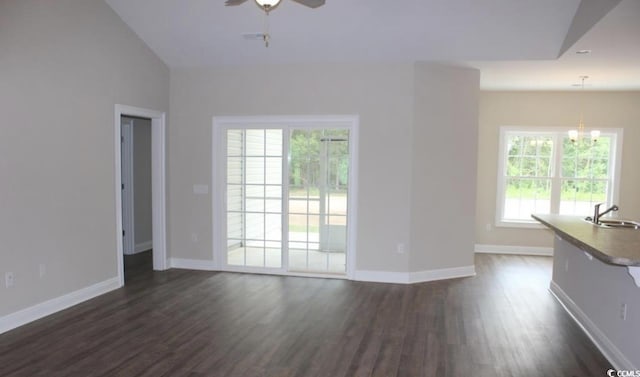 unfurnished living room with lofted ceiling, ceiling fan with notable chandelier, a healthy amount of sunlight, and sink