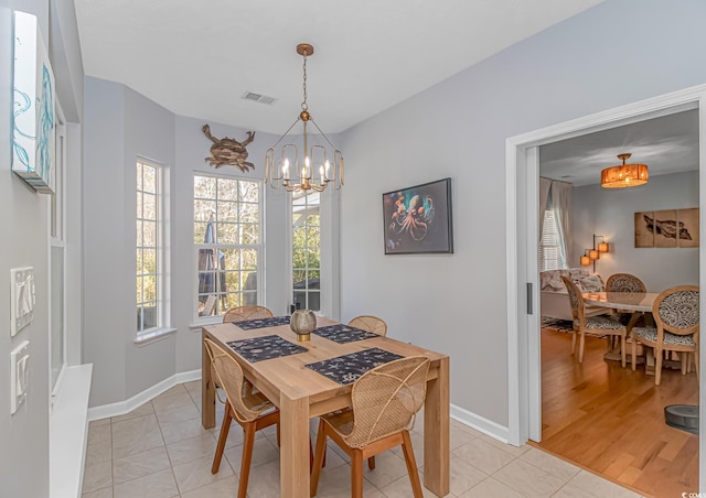 dining area featuring an inviting chandelier and light tile patterned floors